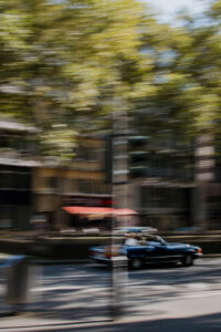 strassenszene-blaues-auto-faehrt-eine-allee-entlang-die-aufnahme-ist-verschwommen-icm-wischtechnik-simuliert-geschwindigkeit